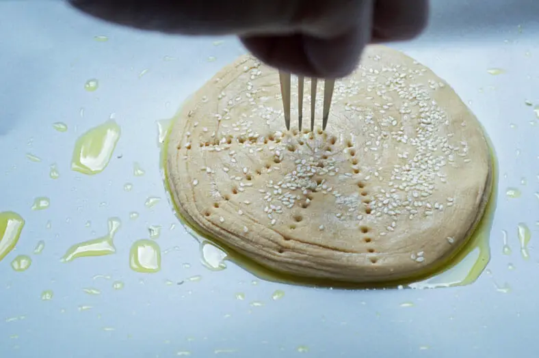 Making symmetrical holes on the dough using fork 