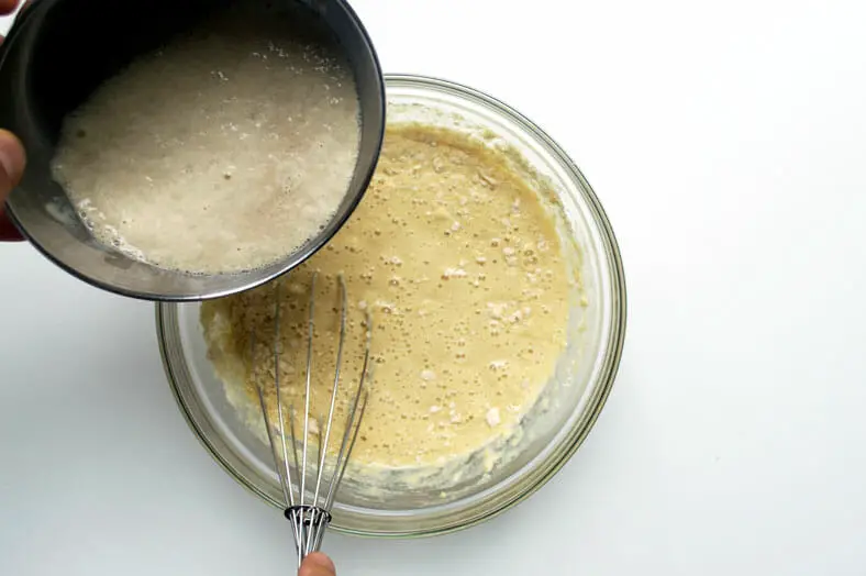 Mixing yeast with flour, milk and eggs mixture