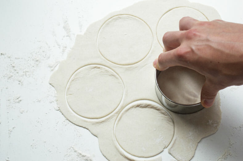 Cutting dough into circle with circular pastry cutter