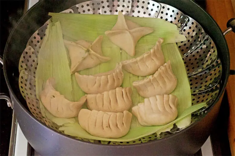 Placing dumplings in the steamer tray for cooking