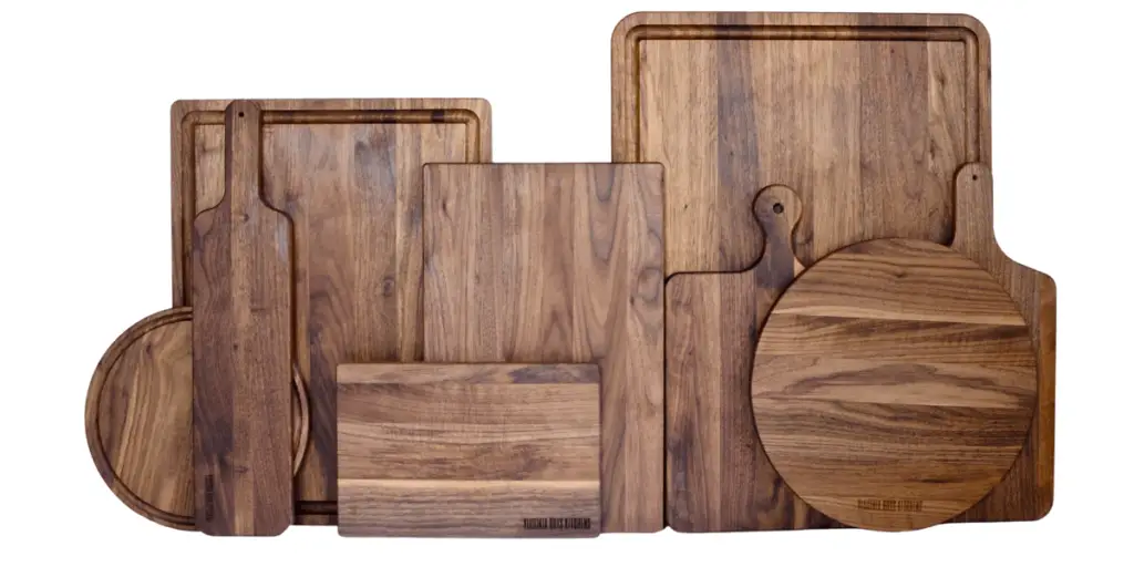 11 wooden cutting boards arranged together in different sizes and shapes