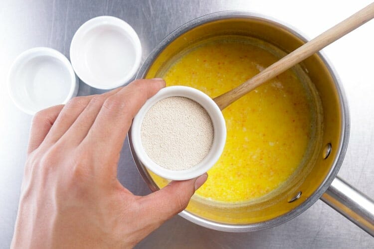 Adding yeast to butter, milk and saffron cooled mix