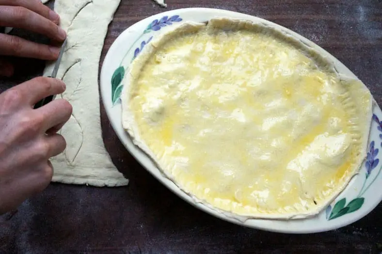Brushing eggwash on top of dough