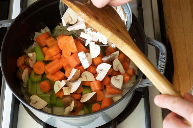 Cooking onions, carrots, mushroom in stockpot