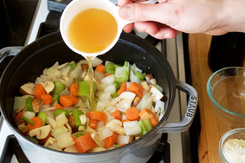 Adding vegetable stock in the stockpot