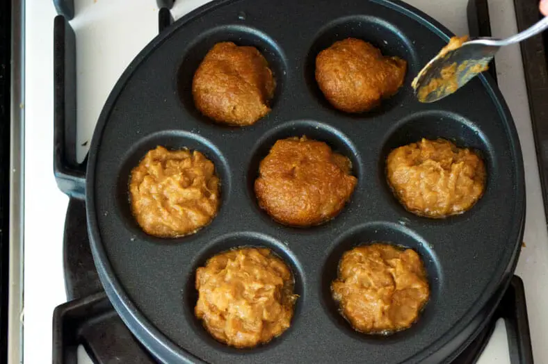 Flipping batter balls in dimpled pan with spoon