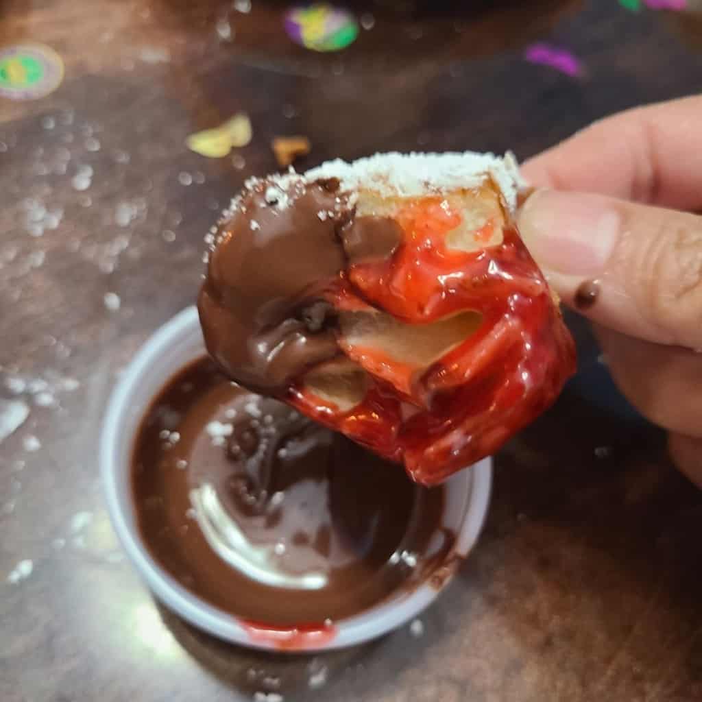 Doughnut dipped in chocolate sauce on half and raspberry on half