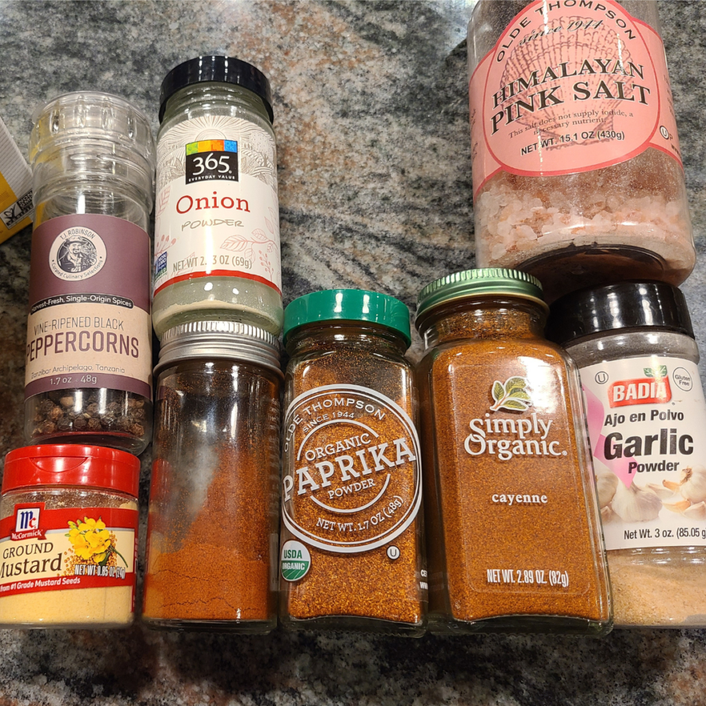 all the seasonings and spices in their containers laid out for this dry brisket rub for smoking recipe