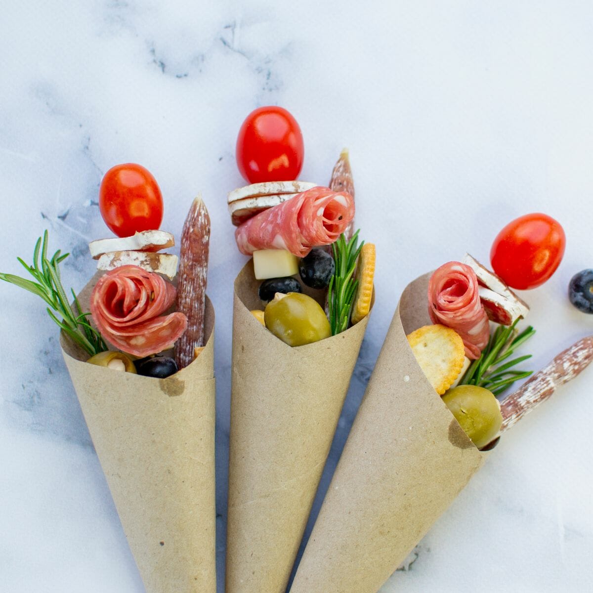 3 charcuterie cones side by side on marble background