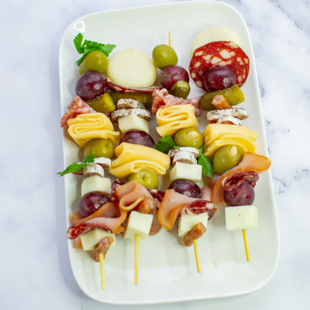 top view of 4 charcuterie skewers in a white ceramic plate
