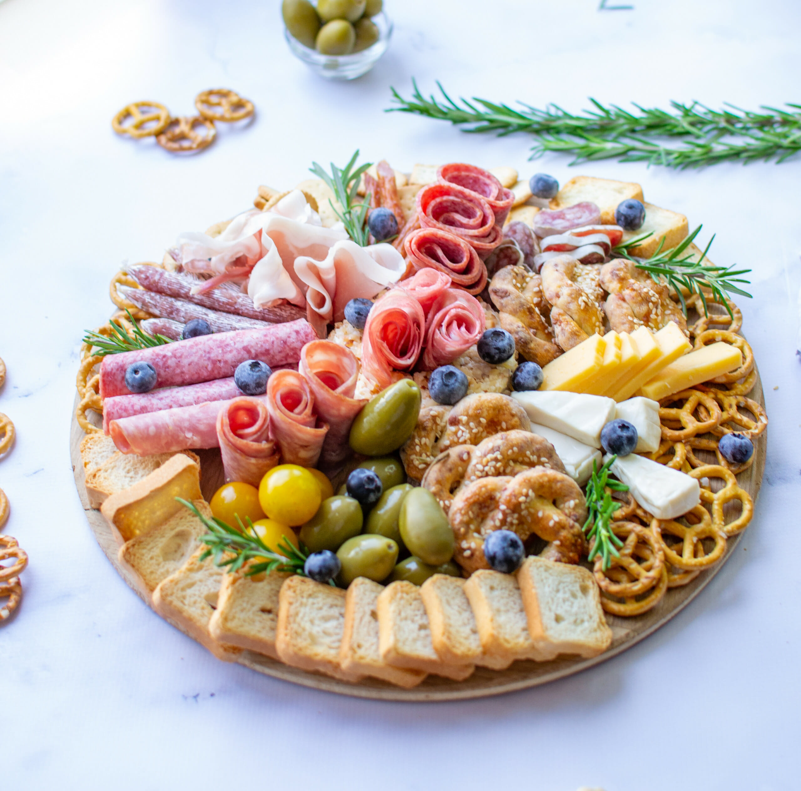 top view of a charcuterie with pretzels olives salami