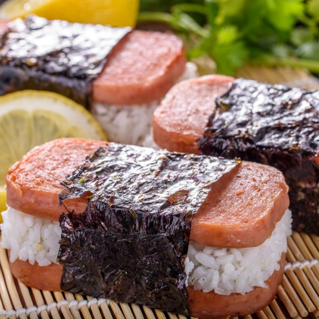 a piece of musubi - which is sushi rice topped with spam and a strip of nori seaweed