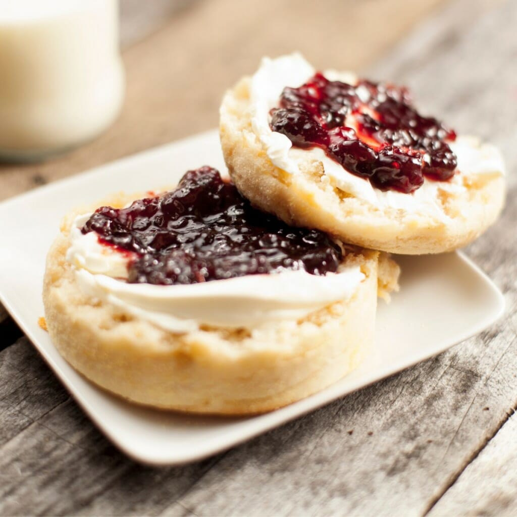 sliced english muffin topped with cream cheese and jam