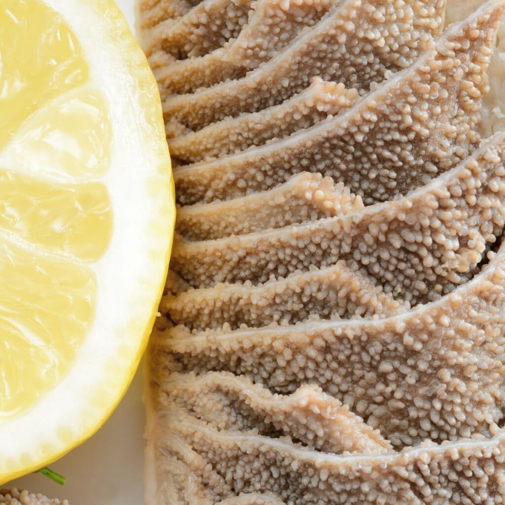 close up top view of brown tripe with lemon