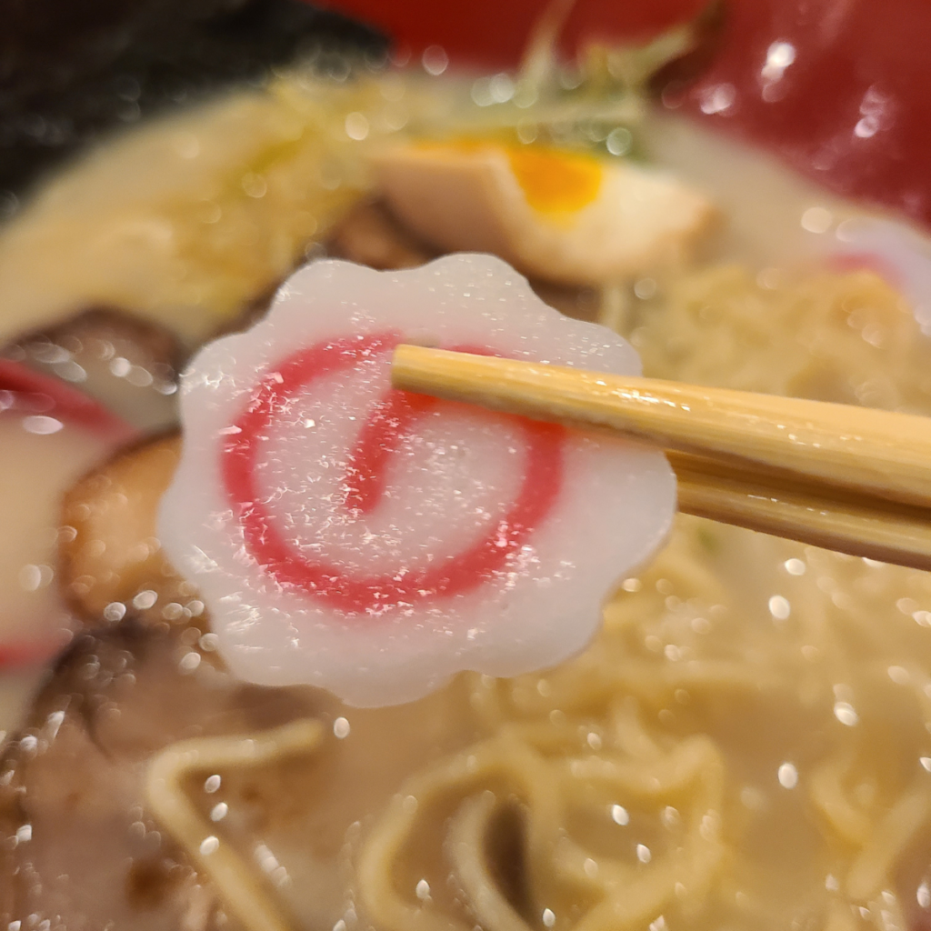 up close picture of sliced fish cake in ramen noodle soup at a japanese restaurant