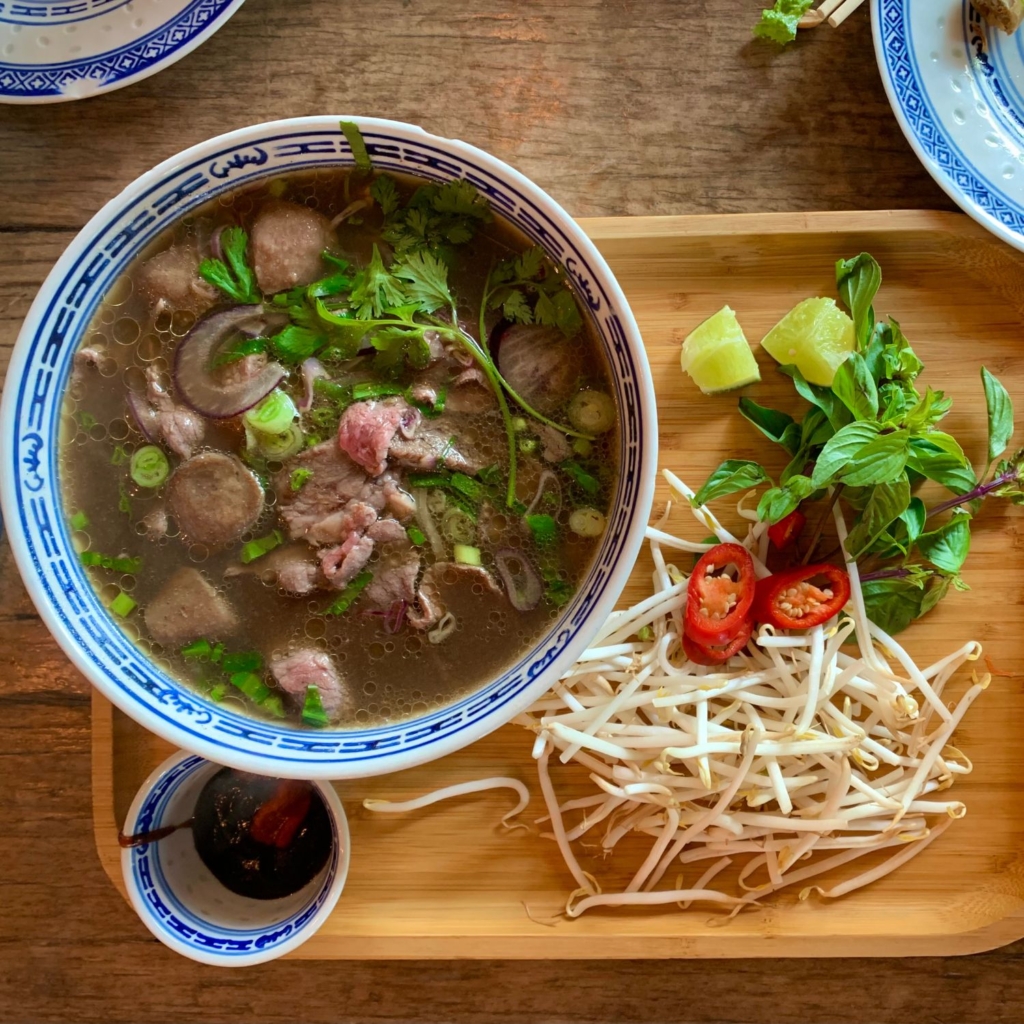top view of beef pho with herbs and bean sprouts