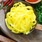 yellow mi quang noodles - a large bowl on wooden table
