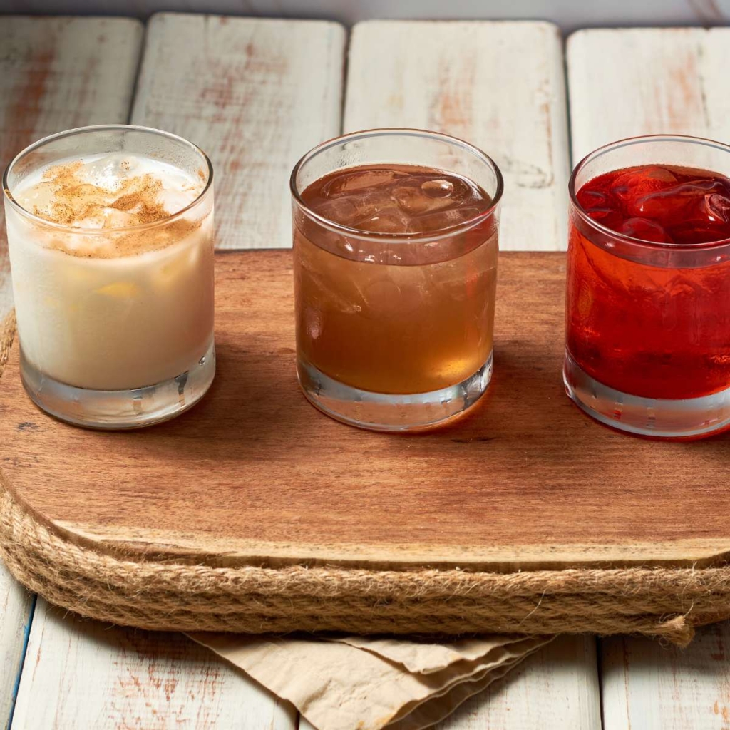 Assortment of beverages presented on a serving board, placed on a table.