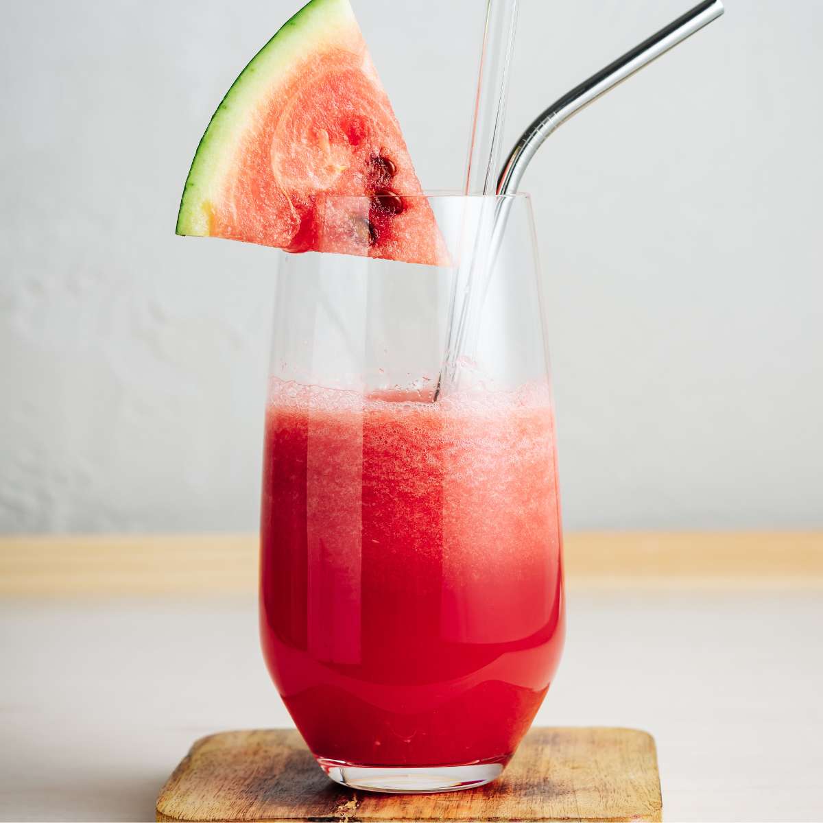 Watermelon juice topped with watermelon slice on table