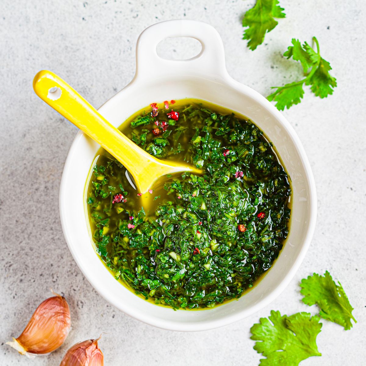 Bowl of green chimichurri sauce, made with fresh herbs and spices