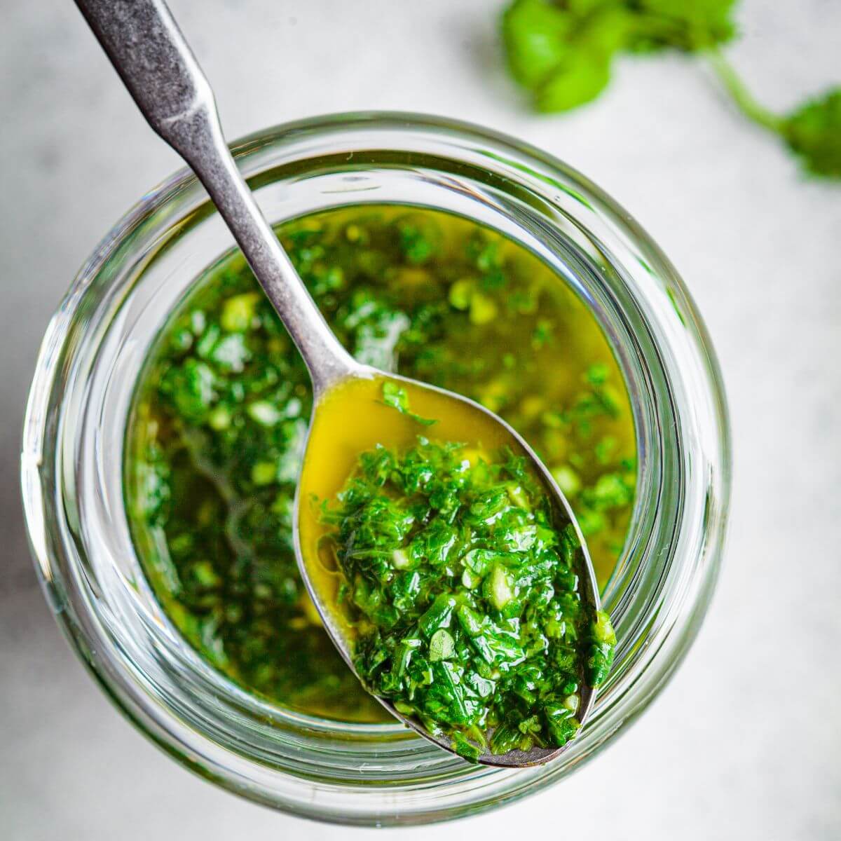 Jar filled with vibrant green chimichurri sauce