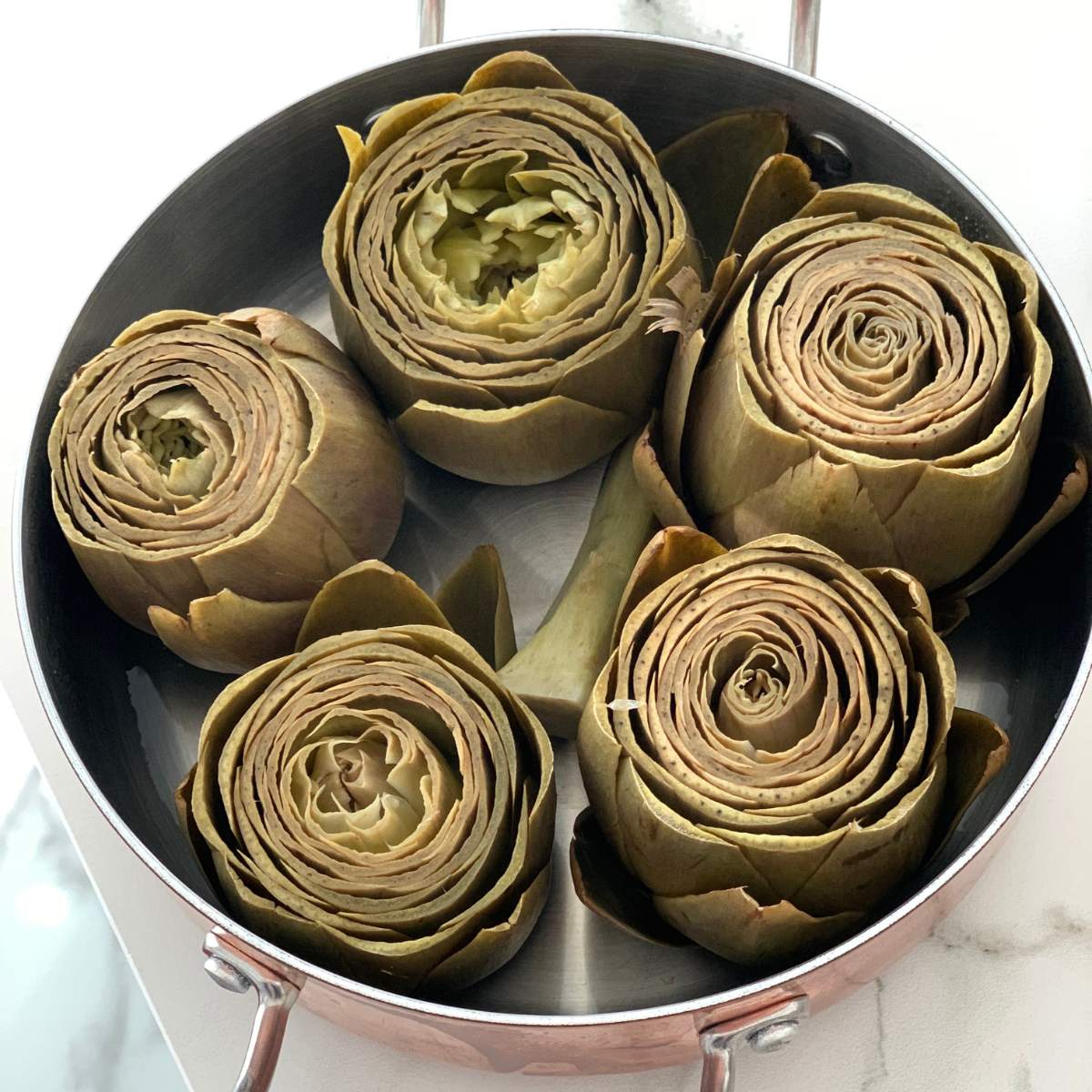Close-up of beautifully arranged and cooked artichokes on a pot
