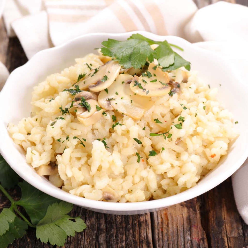 Risotto with mushrooms topped  with coriander in a bowl on table