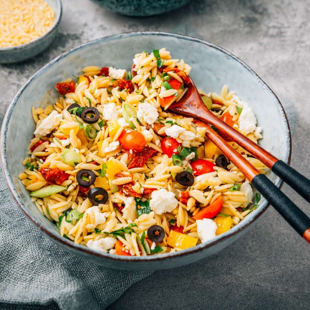 Orzo pasta in bowl with spoon on a table

