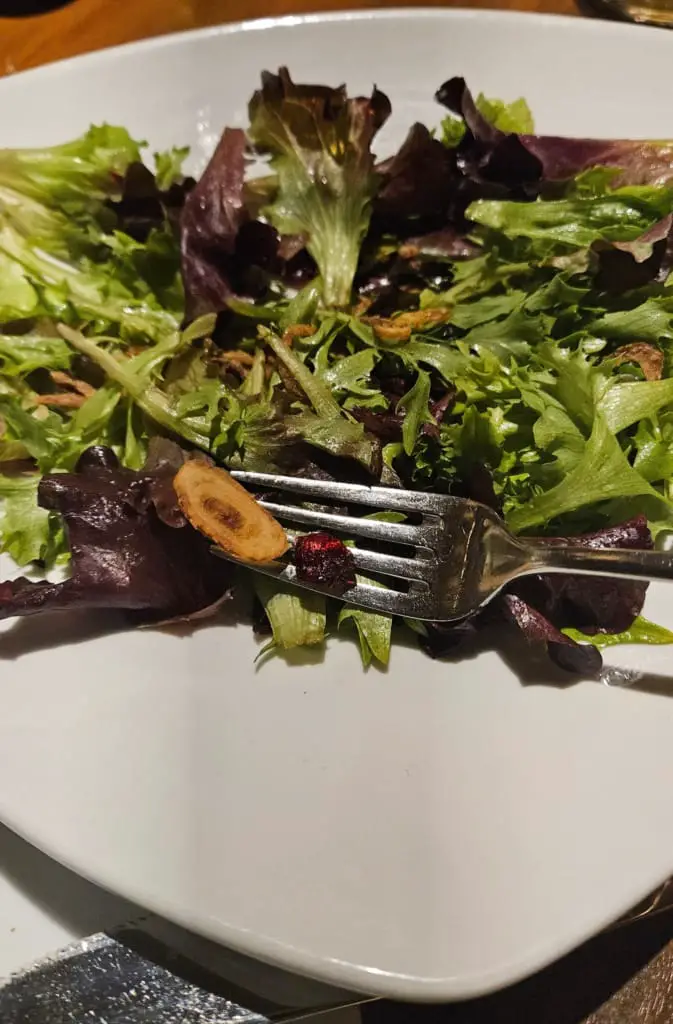Spinach and arugula salad on a plate with fork.